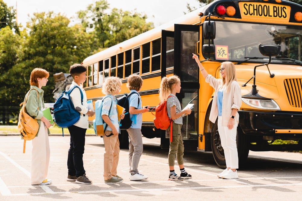 teacher talking to students as they board bus as part of establishing an emergency response plan